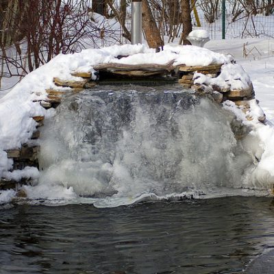 Koi pond with waterfall frozen